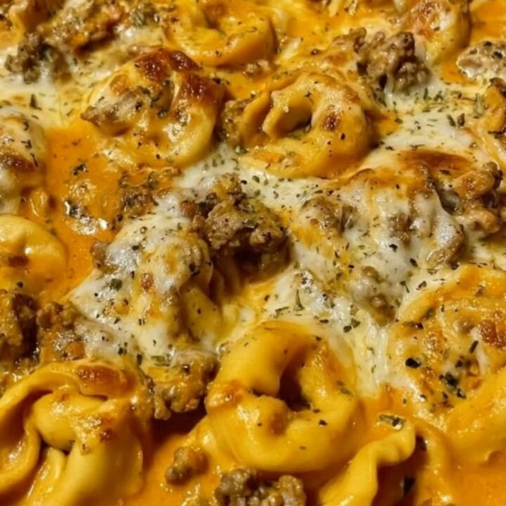 A bubbly cast iron skillet filled with creamy beef and cheese tortellini, topped with melted mozzarella.