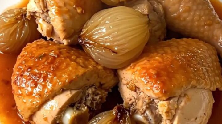 A slow cooker filled with chicken thighs, shallots, and a rich red wine vinegar sauce.