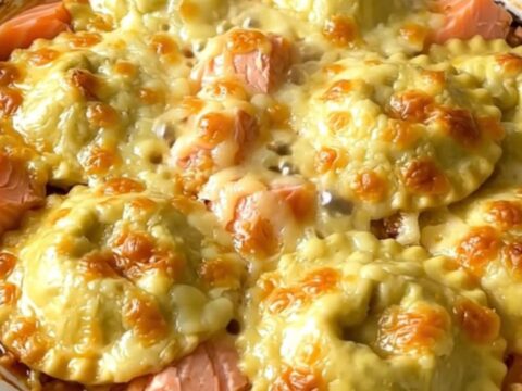 A close-up of a golden, creamy salmon and leek gratin served in a white bowl.