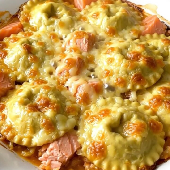 A close-up of a golden, creamy salmon and leek gratin served in a white bowl.