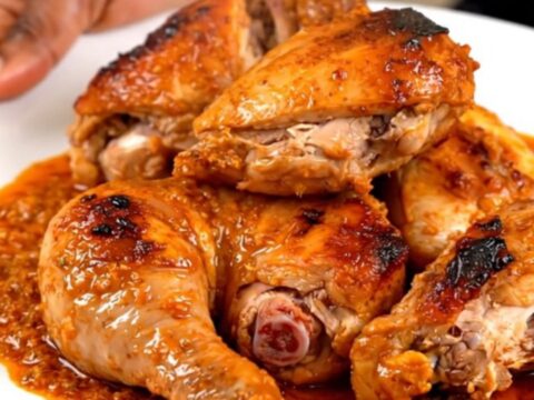 A close-up of tender, spiced tandoori chicken legs served on a white plate.