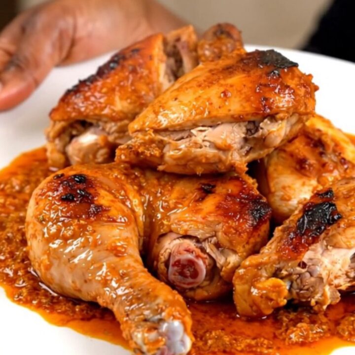 A close-up of tender, spiced tandoori chicken legs served on a white plate.