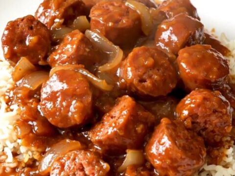 A close-up of a steaming bowl of Creole sausage rougail served over fluffy white rice.