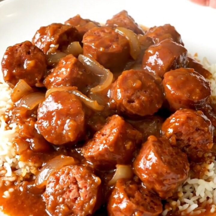 A close-up of a steaming bowl of Creole sausage rougail served over fluffy white rice.