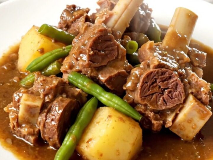 A rustic slow cooker lamb navarin with tender chunks of meat, potatoes, and green beans in a savory broth.