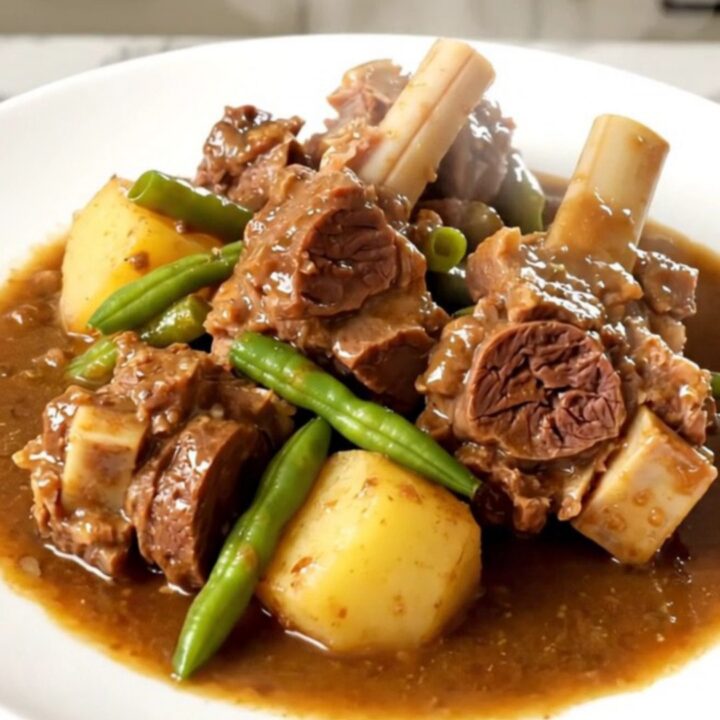 A rustic slow cooker lamb navarin with tender chunks of meat, potatoes, and green beans in a savory broth.