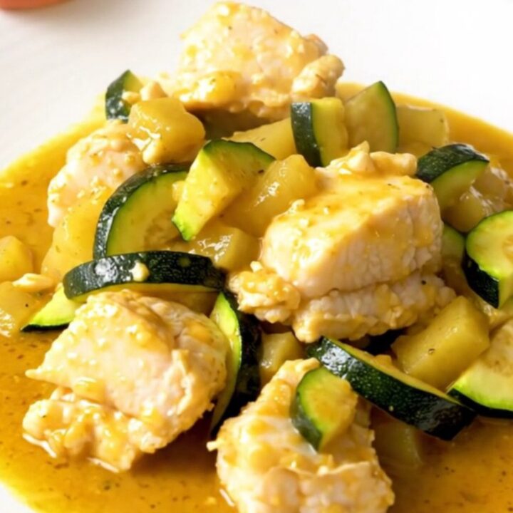 A slow cooker filled with cod fillets, zucchini, and a creamy coconut colombo sauce.