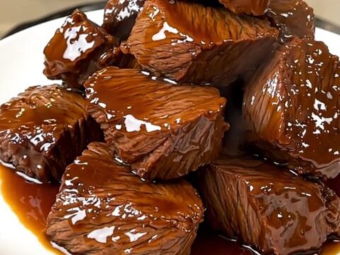 A close-up of tender, glazed beef chuck chunks in a dark, glossy balsamic sauce.