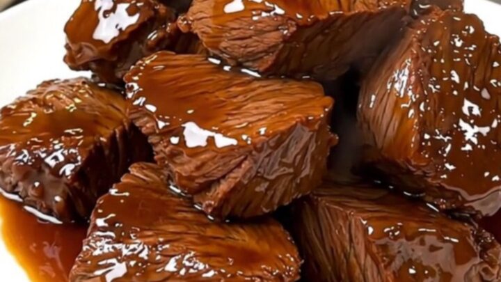 A close-up of tender, glazed beef chuck chunks in a dark, glossy balsamic sauce.