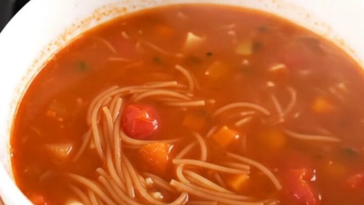 A rustic tomato and vermicelli soup in a slow cooker on a bright kitchen counter.