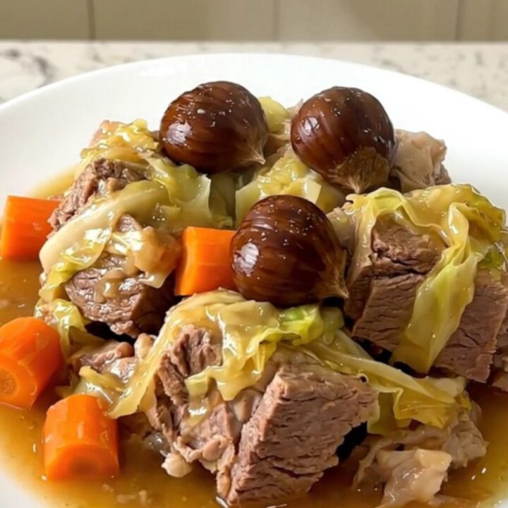 A rustic slow cooker potée with salt pork, sausages, cabbage, and chestnuts in a white bowl.