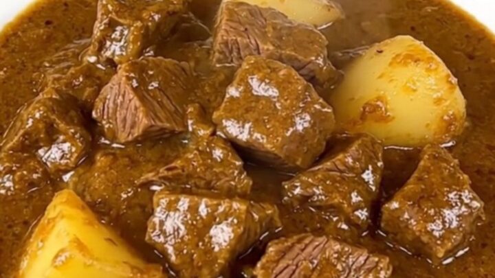 A close-up view of the finished beef Massaman curry in a slow cooker insert.