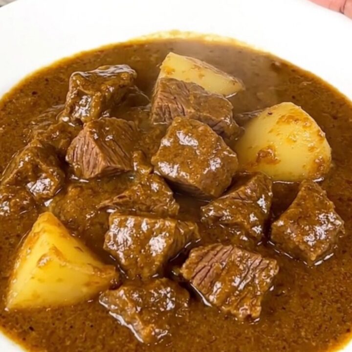 A close-up view of the finished beef Massaman curry in a slow cooker insert.