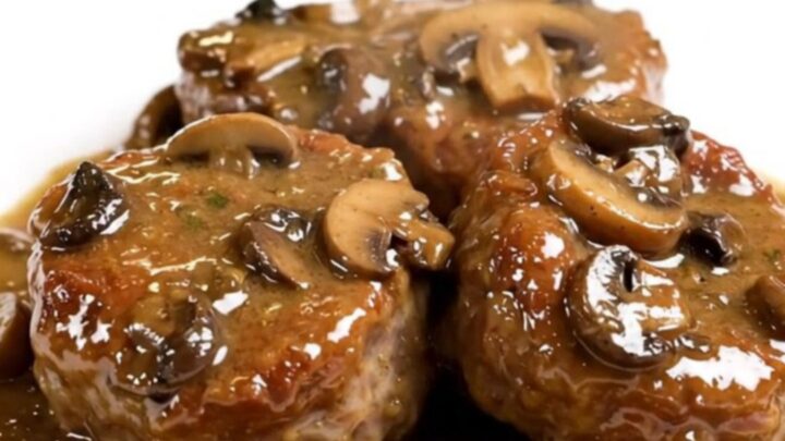 A plate of tender veal paupiettes smothered in a creamy mushroom sauce on a white plate.
