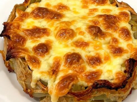 A close-up of a finished slow cooker tartiflette with golden melted cheese and bacon.