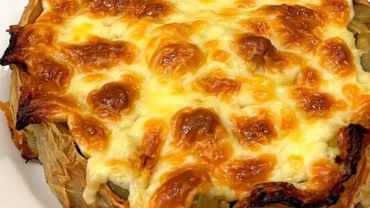 A close-up of a finished slow cooker tartiflette with golden melted cheese and bacon.
