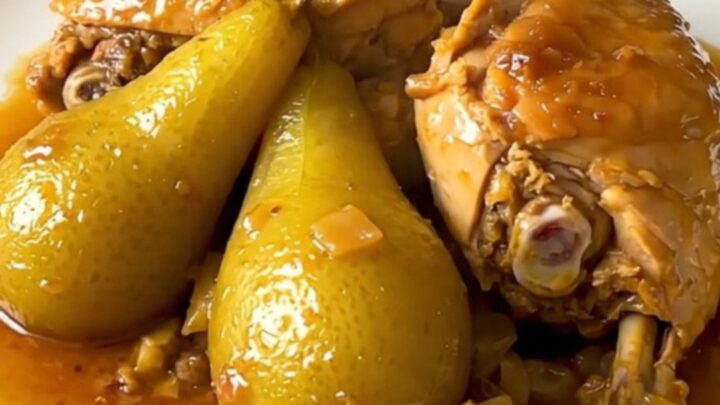 A rustic bowl of slow-cooked chicken drumsticks glazed with honey and tender pear slices.