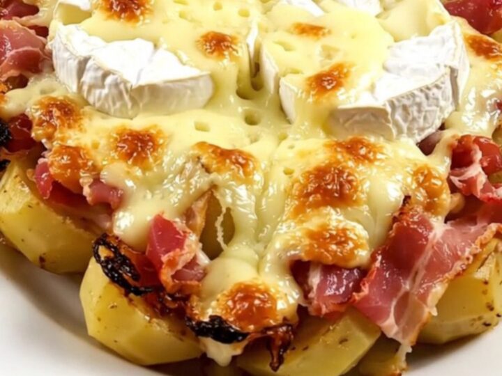 A top-down view of a slow cooker filled with bacon, potatoes, and two wheels of Camembert.