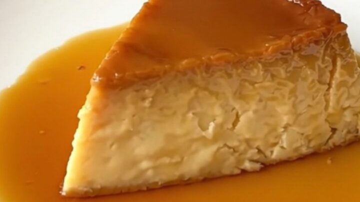 A slice of glossy, firm vanilla and orange blossom flan on a white plate.