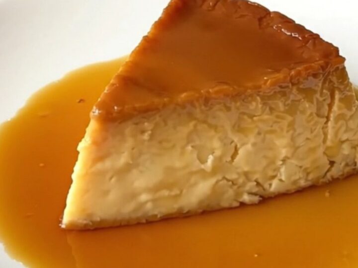 A slice of glossy, firm vanilla and orange blossom flan on a white plate.