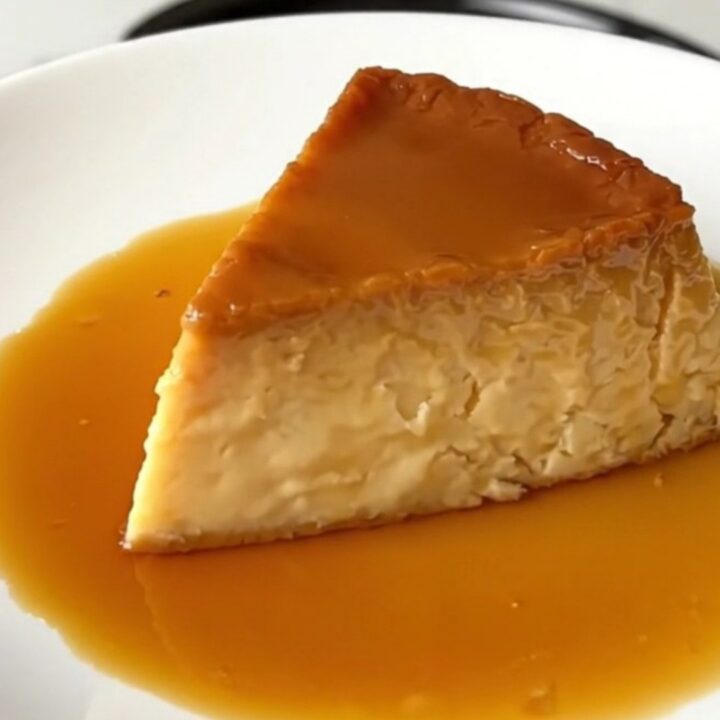 A slice of glossy, firm vanilla and orange blossom flan on a white plate.