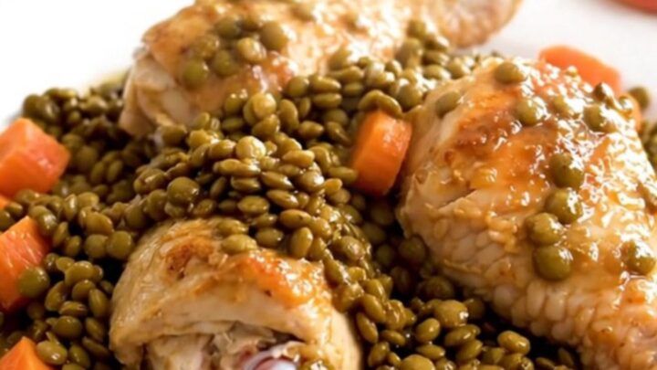 A close-up of tender chicken drumsticks and perfectly cooked green lentils served on a white plate.