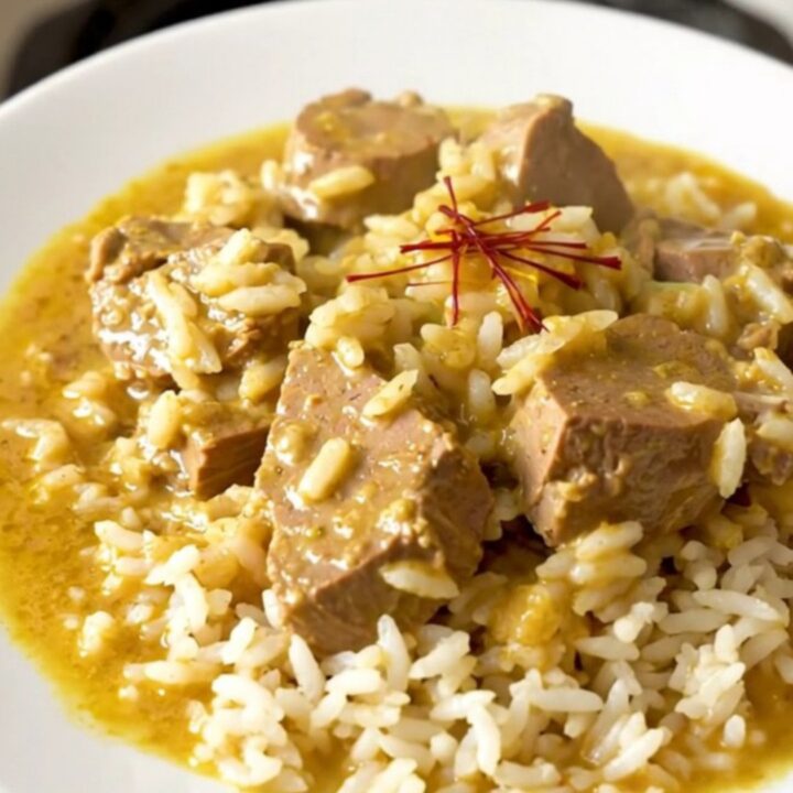 Slow cooker saffron veal blanquette served on a white plate with steamed rice.