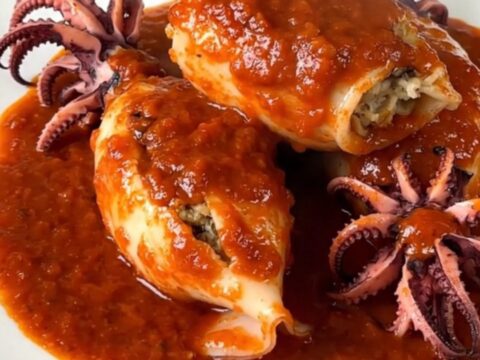 Assiette d'encornets farcis nappés de sauce tomate brillante.