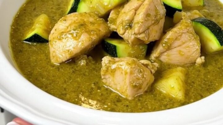 A steaming bowl of creamy green chicken curry with zucchini slices and a rich coconut milk sauce.