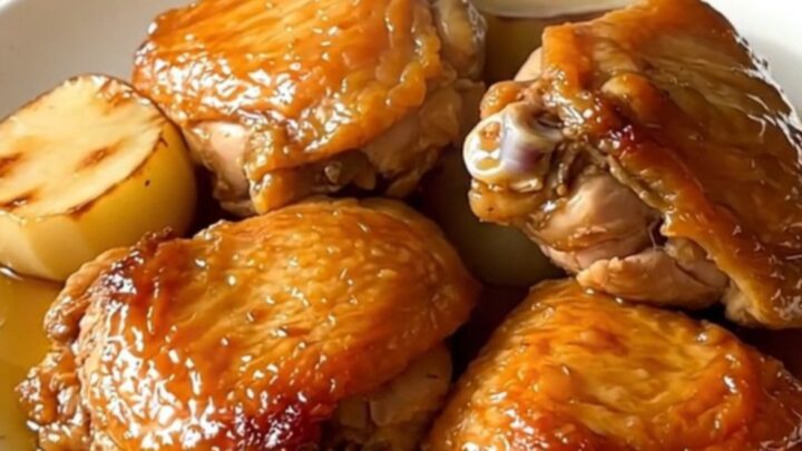 Slow cooker honey glazed chicken thighs with tender turnips on a white plate.