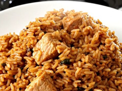 A rustic slow cooker filled with chicken, sausage, and peppers in a rich tomato sauce.