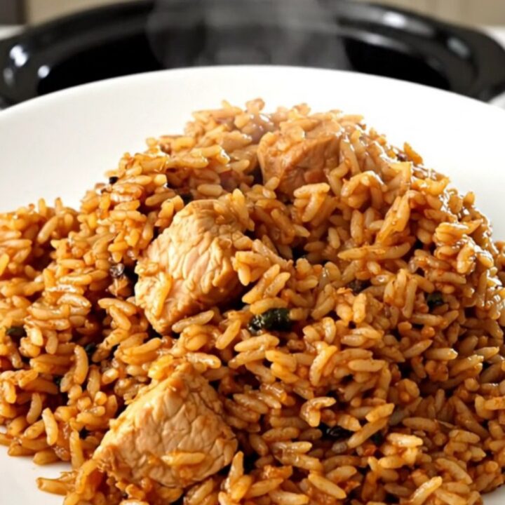 A rustic slow cooker filled with chicken, sausage, and peppers in a rich tomato sauce.
