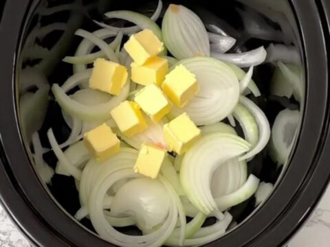 A slow cooker filled with golden, caramelized onions and broth, ready to be served as a comforting meal.