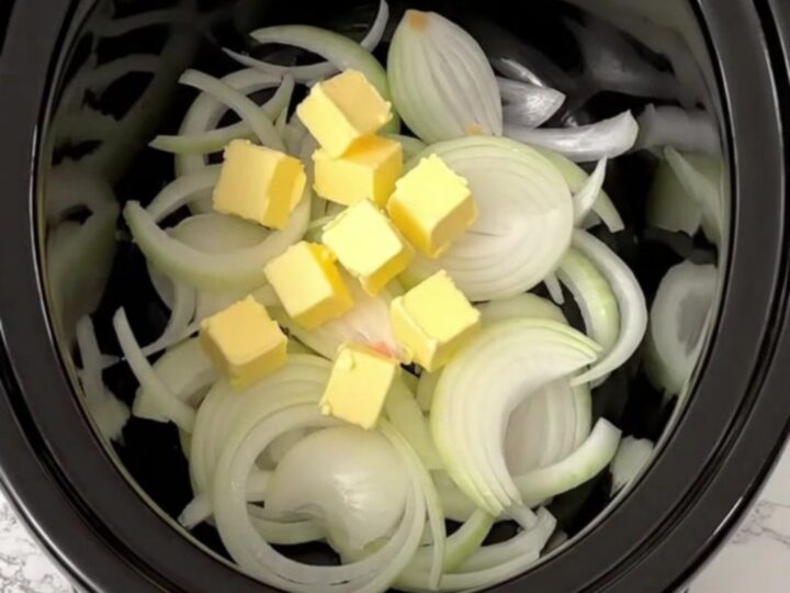 A slow cooker filled with golden, caramelized onions and broth, ready to be served as a comforting meal.