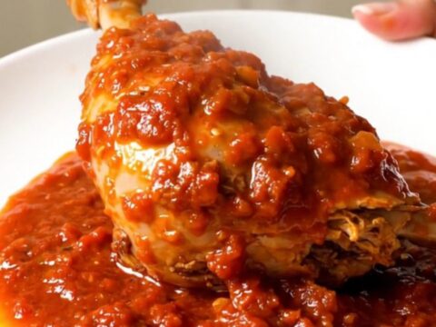 Two tender turkey drumsticks smothered in a rich, glossy tomato oregano sauce on a white plate.