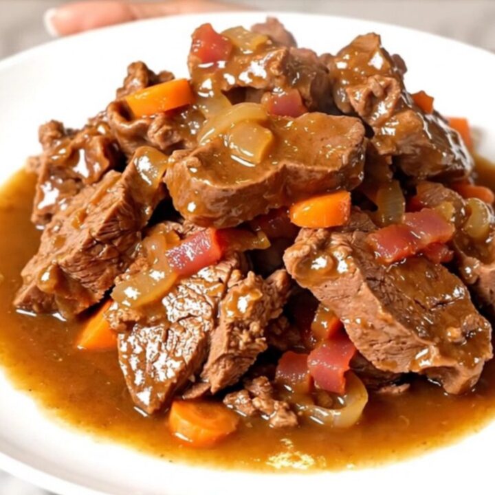 A rustic plate featuring tender slow-cooked veal tendrons topped with bacon, pearl onions