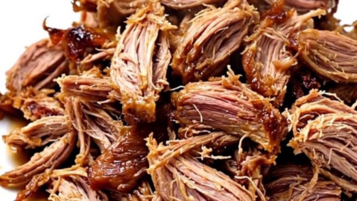 A slow cooker filled with raw pork roast, pineapple chunks, and sliced onions before cooking.