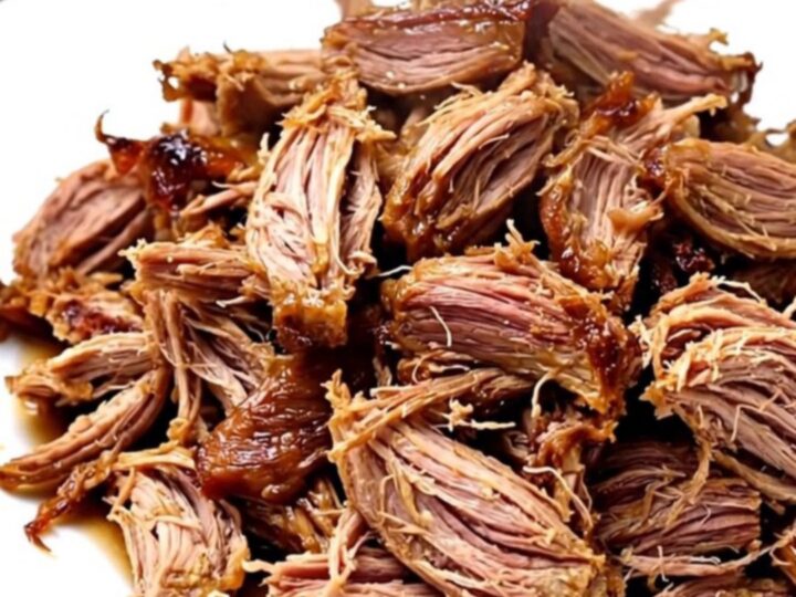A slow cooker filled with raw pork roast, pineapple chunks, and sliced onions before cooking.