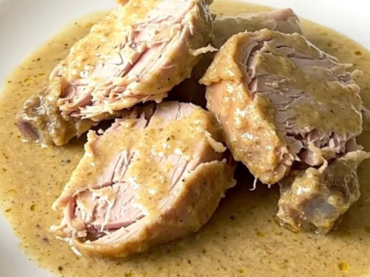 Dinde crémeuse à l'estragon servie dans une assiette blanche avec une sauce onctueuse.