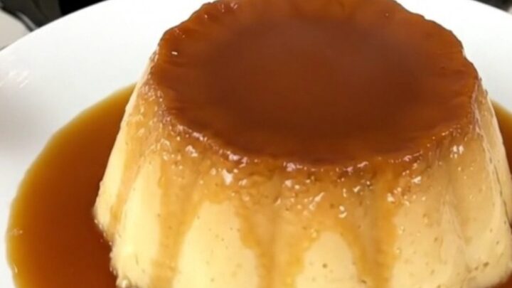 A top-down view of a black slow cooker insert showing the layered ingredients for a coffee caramel flan.