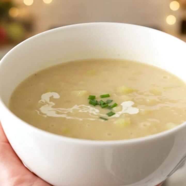 A bowl of creamy, velvety celery and potato soup steaming on a table.