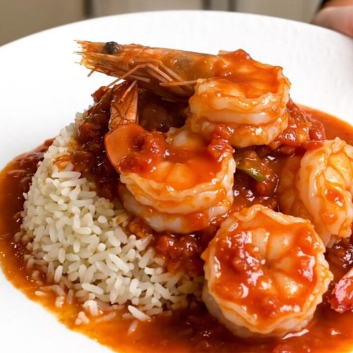 A steaming bowl of shrimp rougail served over white rice with a rich tomato sauce.