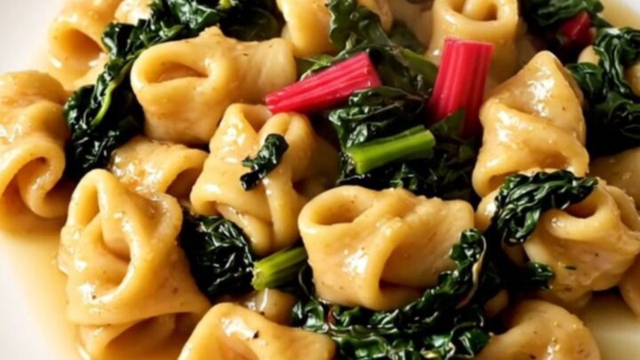 A steaming, rustic stew of figatelli sausage, diced potatoes, and Swiss chard in a white bowl.