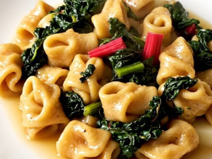 A steaming, rustic stew of figatelli sausage, diced potatoes, and Swiss chard in a white bowl.