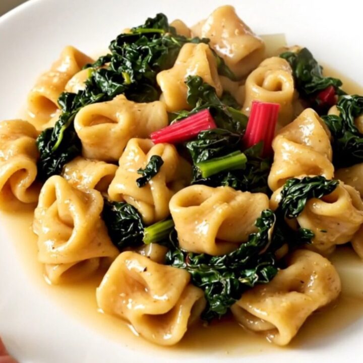 A steaming, rustic stew of figatelli sausage, diced potatoes, and Swiss chard in a white bowl.