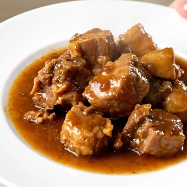 A rustic Alsatian stew featuring sausages and vegetables in a white bowl.