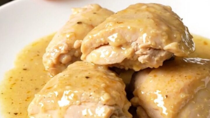 Finished Riesling chicken with tender onions in a white bowl, showing a glossy sauce.