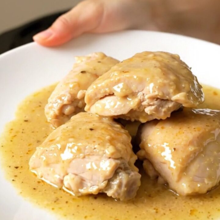 Finished Riesling chicken with tender onions in a white bowl, showing a glossy sauce.