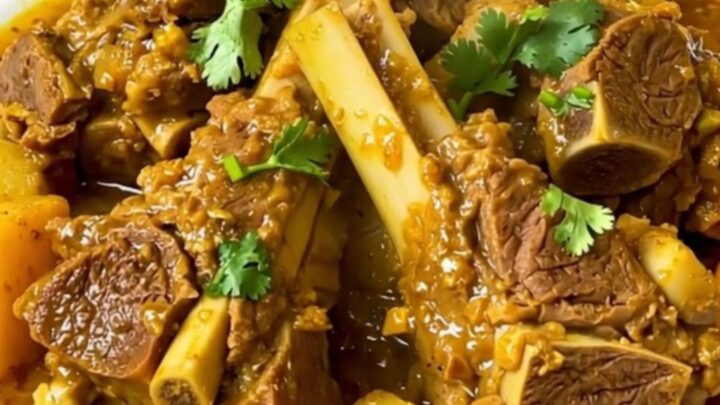 Slow cooker lamb tagine served in a white bowl with sweet potatoes and aromatic spices.