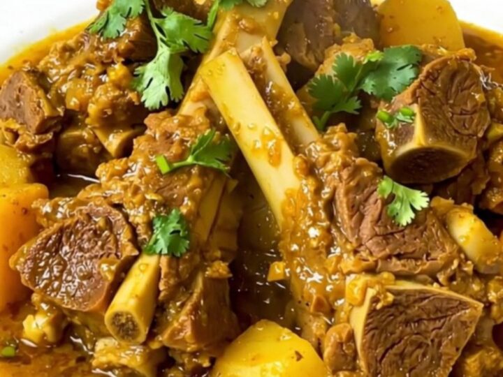 Slow cooker lamb tagine served in a white bowl with sweet potatoes and aromatic spices.